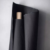 Roll of black fabric on grey background