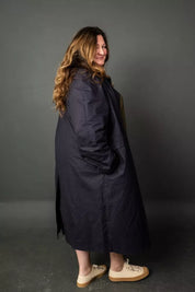 Woman wearing a dark blue coat against a gray background