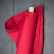 Roll of red fabric on a gray background