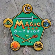 Embroidered patch with 'Magic Outside' text and camping-themed icons on a textured surface.