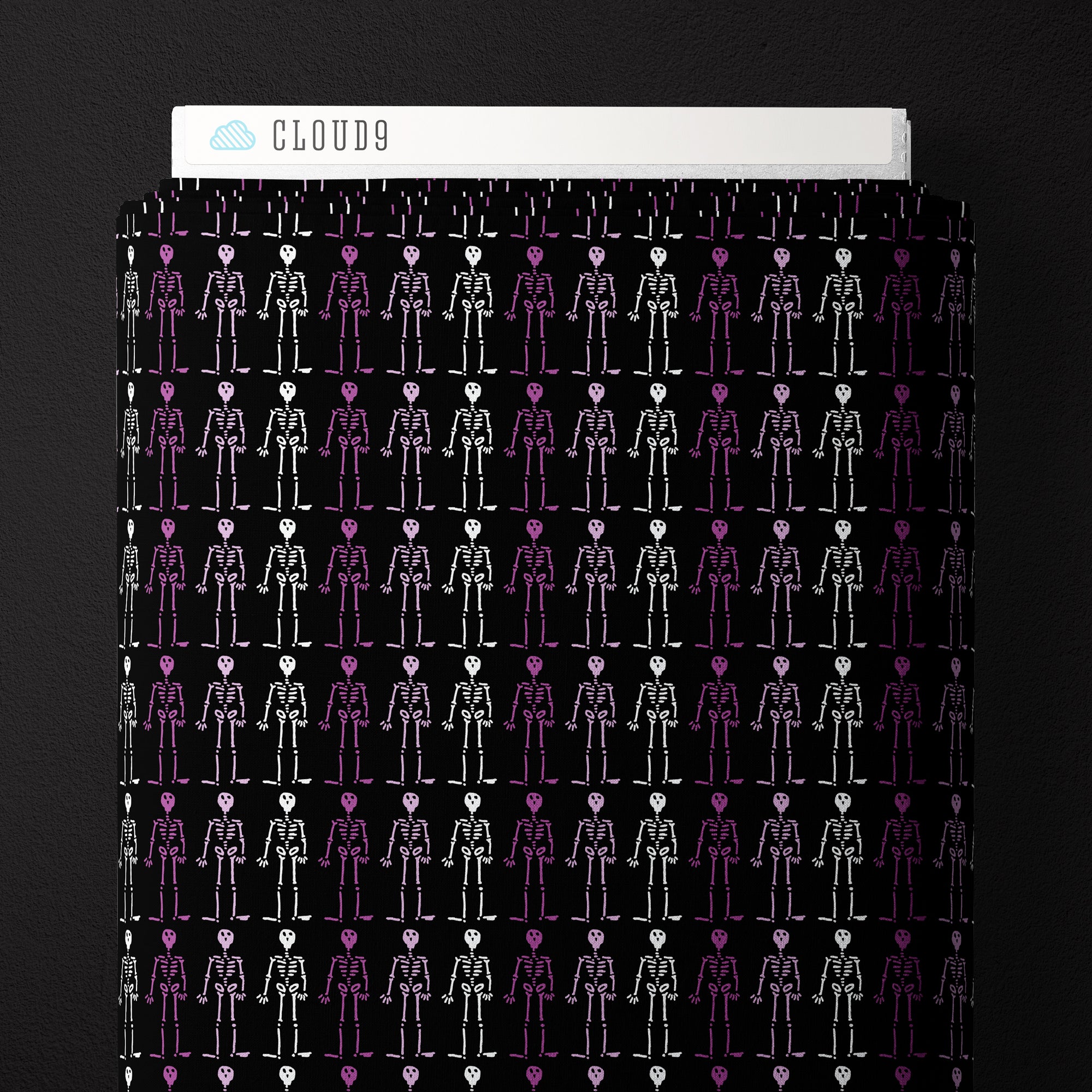 Fabric with black background and white and purple skeletons.