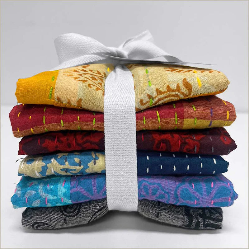 Stack of kantha fabric tied with a white ribbon