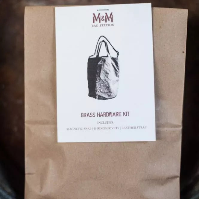 Brown paper package with a label featuring a black and white illustration of a bag on a dark background.
