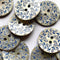 Patterned buttons with blue floral designs on a white background