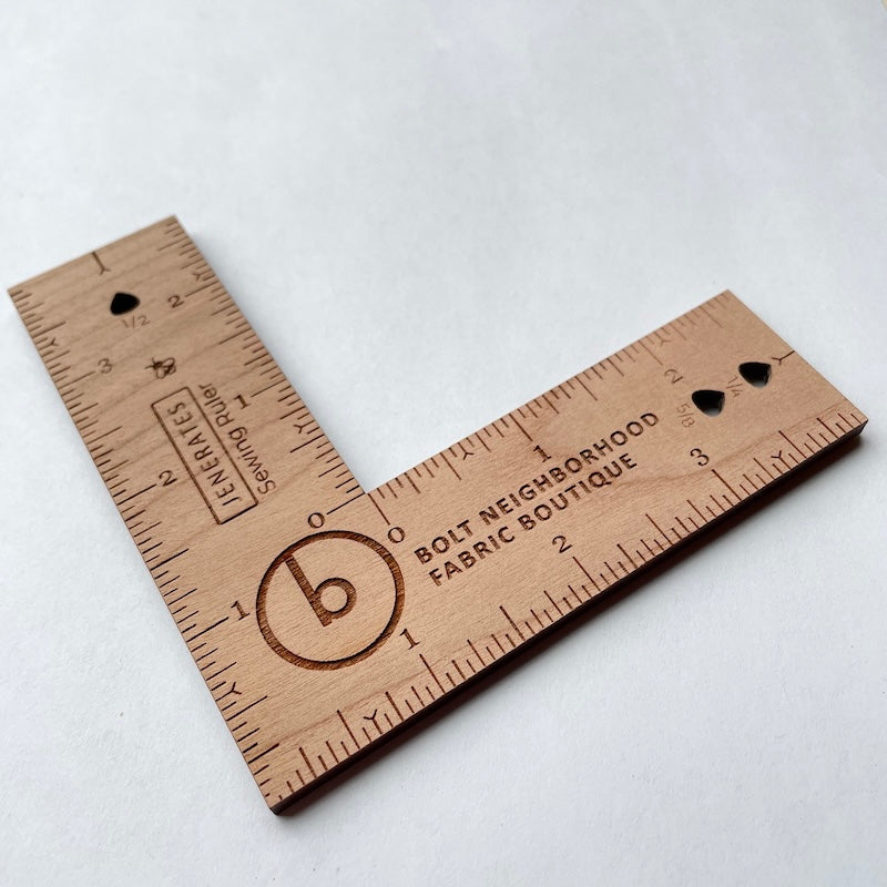 Wooden ruler with engraved measurements and branding on a white background