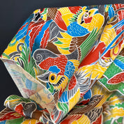Colorful fabric with bird pattern against a dark background.