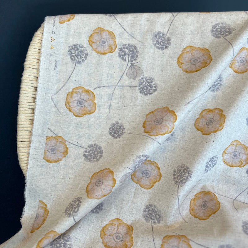 Floral patterned fabric draped over a wicker chair on a dark background