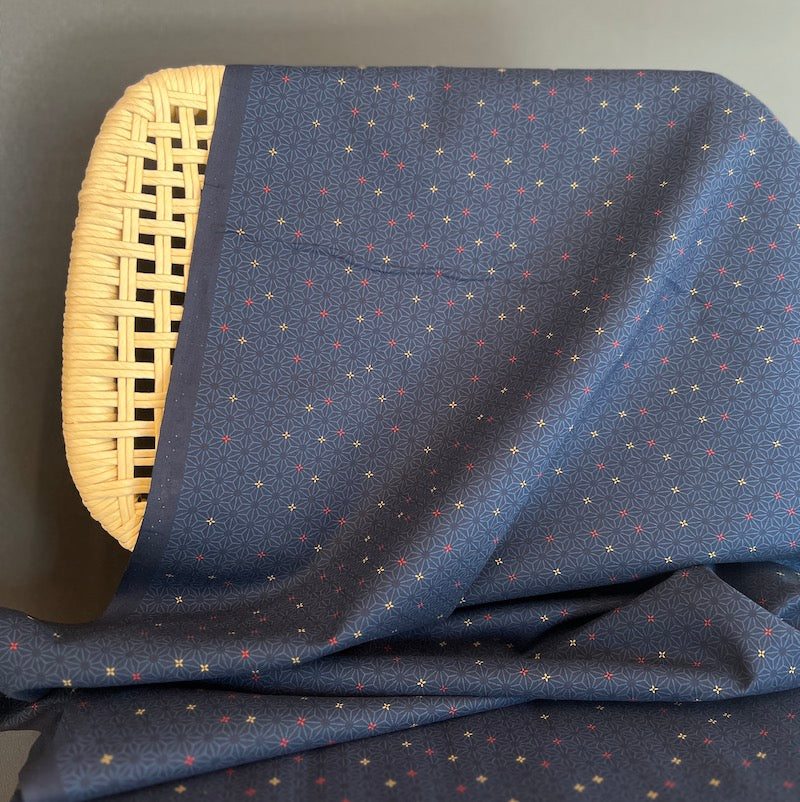 Blue fabric with geometric pattern draped over a wicker chair.