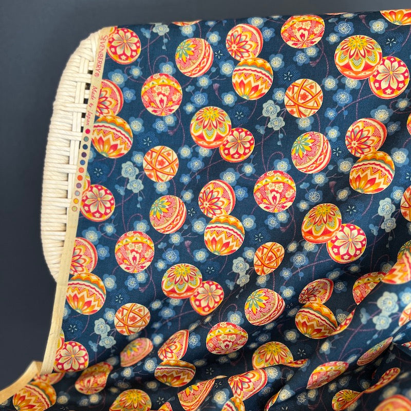 Colorful patterned fabric with circular designs on a dark background