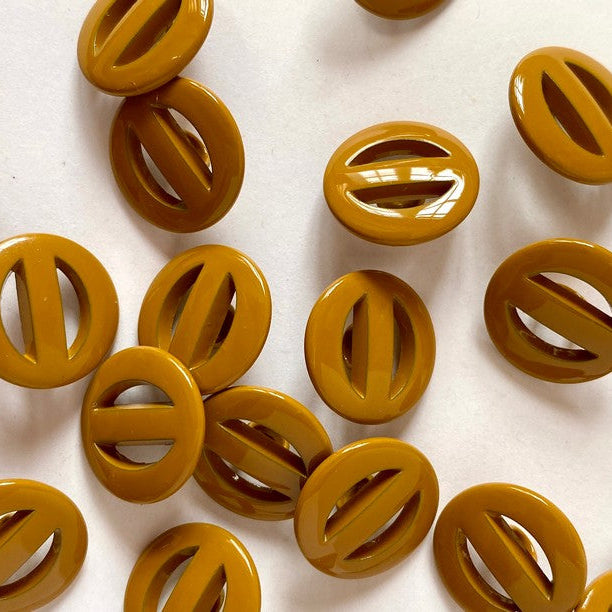 mustard buttons with a central cutout on a white background