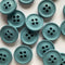 Pattern of teal buttons on a light pink background