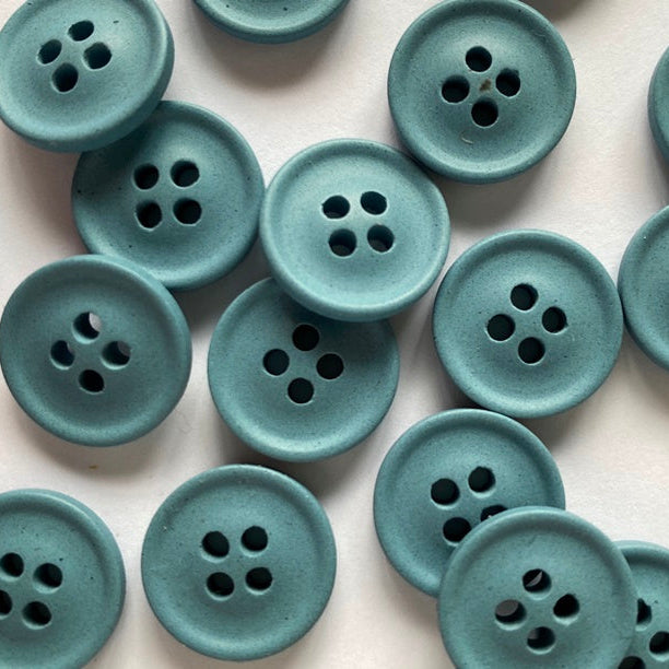 Pattern of teal buttons on a light pink background