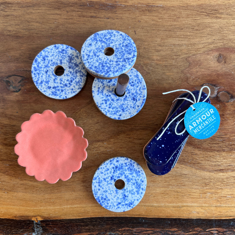 Decorative items including blue speckled donut-shaped objects and a pink scalloped object on a wooden surface.