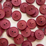 Pink buttons with two holes on a white background
