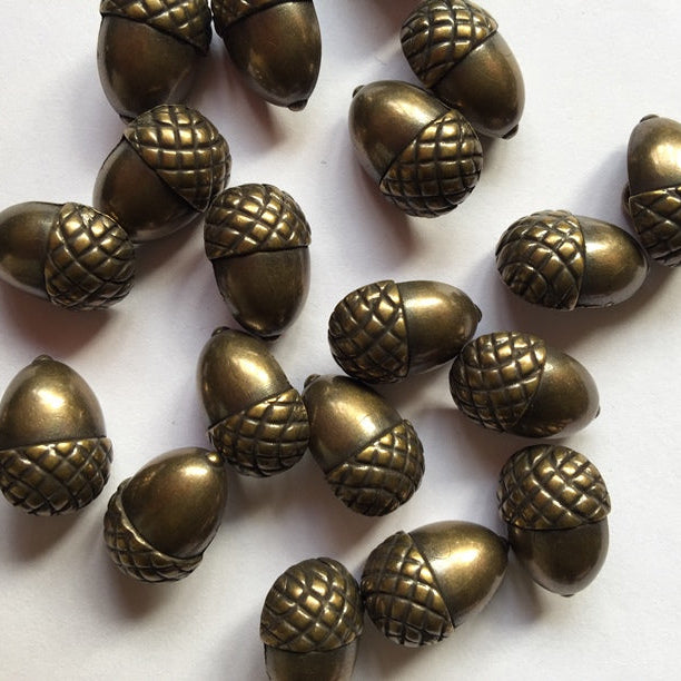 Bronze acorn-shaped buttons on a white background