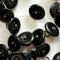 Close-up of black buttons with gold centers on a white background