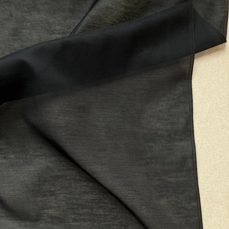 Black fabric draped over a neutral background