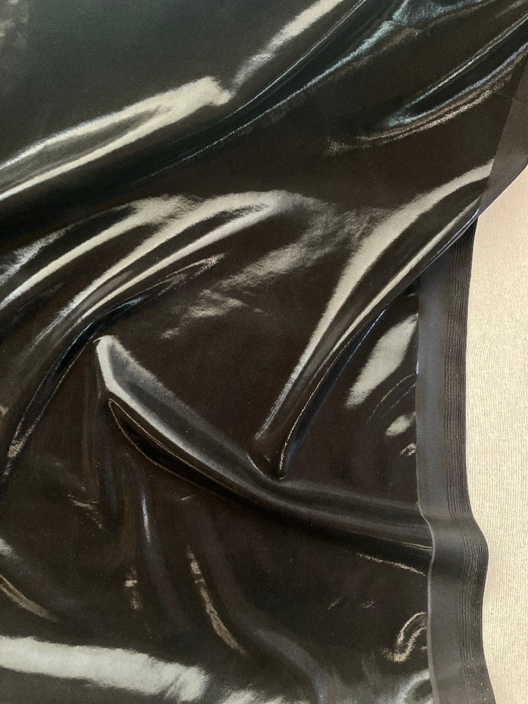 Shiny black fabric on a textured surface