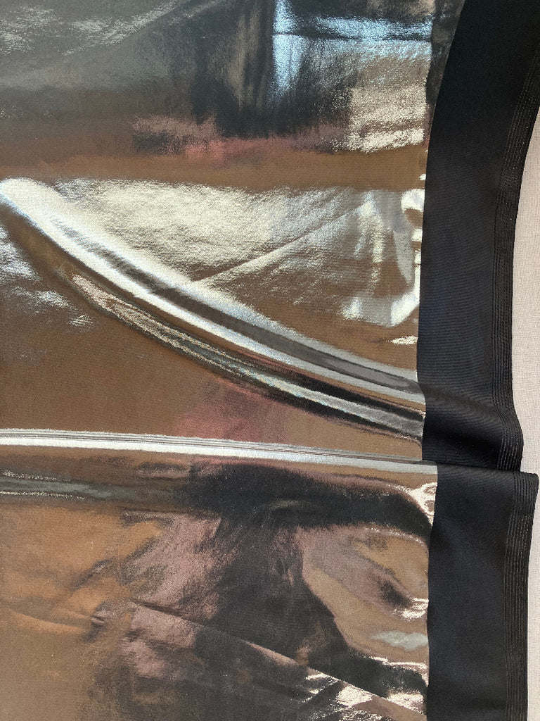 Close-up of a metallic fabric with abstract patterns on a plain background