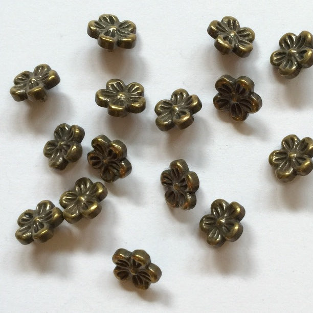 Bronze flower-shaped metal buttons on a white background