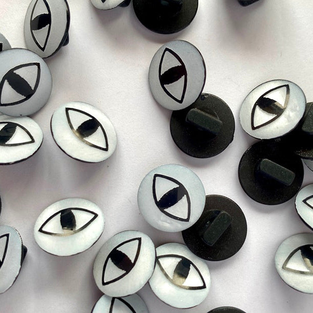 Black and white eye-shaped buttons on a white background