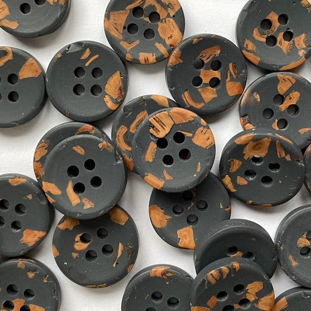 Collection of khaki buttons with brown accents on a white background