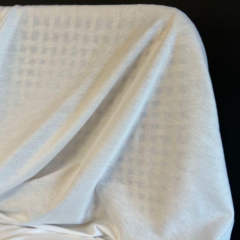 White textured fabric draped over a black background