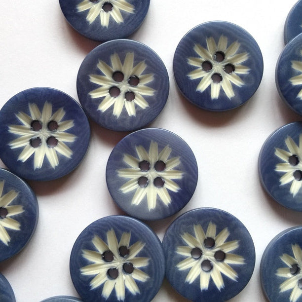 Blue buttons with white floral patterns on a white background