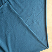 Blue fabric with a diagonal crease on a beige background
