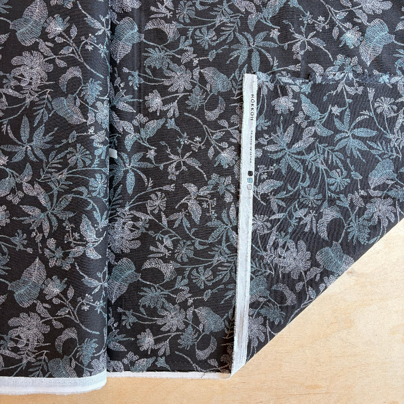 Floral patterned fabric with a ruler for scale on a wooden surface