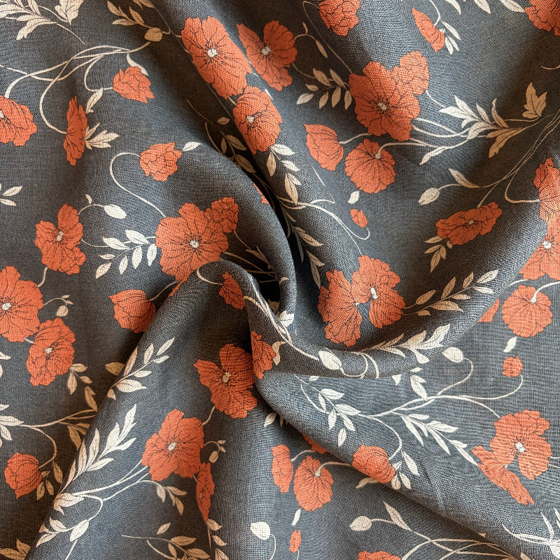 Floral fabric with orange flowers and green leaves on a dark blue background