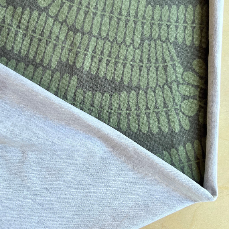 Close-up of fabric with green leaf pattern on gray background