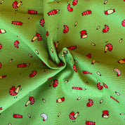 Green fabric with cartoonish red and yellow creature pattern