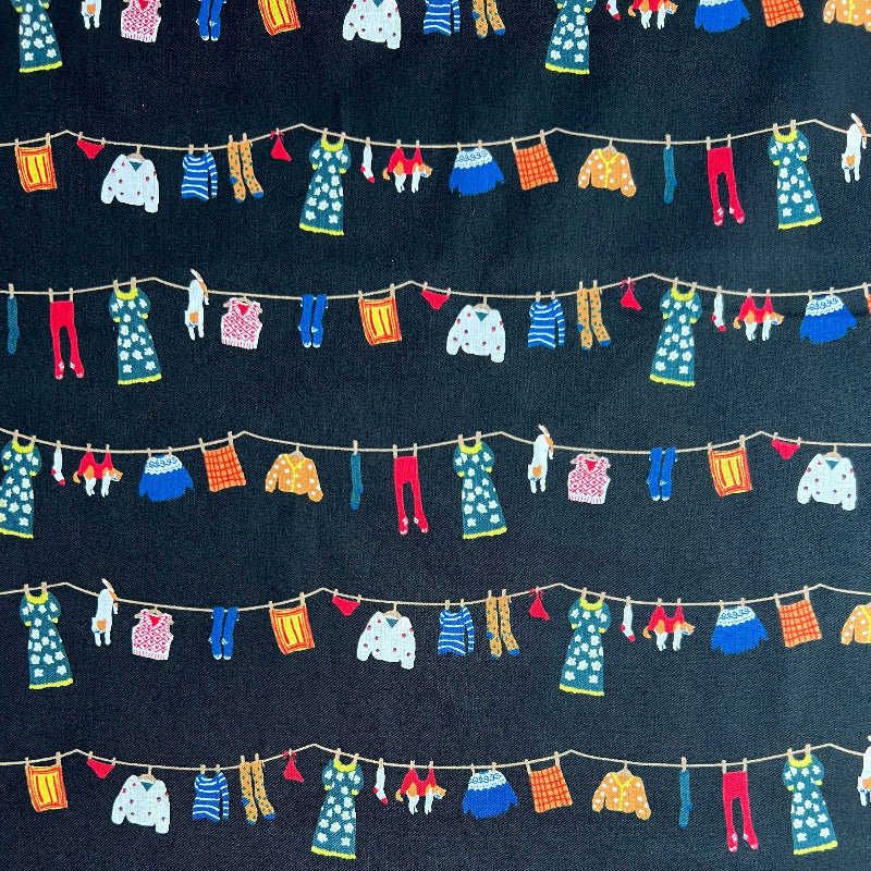 Colorful miniature clothesline with various garments on a dark background