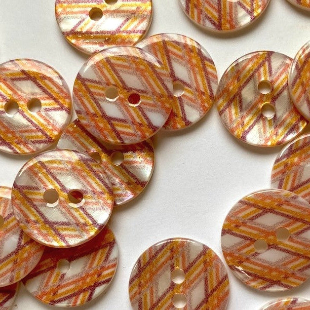 Patterned buttons with orange and brown design on a white background