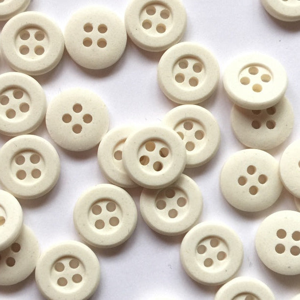 White buttons with four holes on a white background