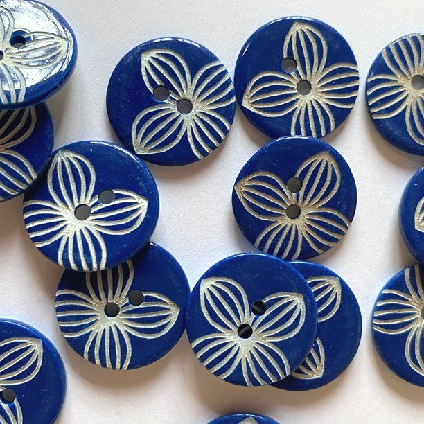 Blue buttons with white floral patterns on a white background