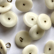 White buttons with gold hardware on a white background