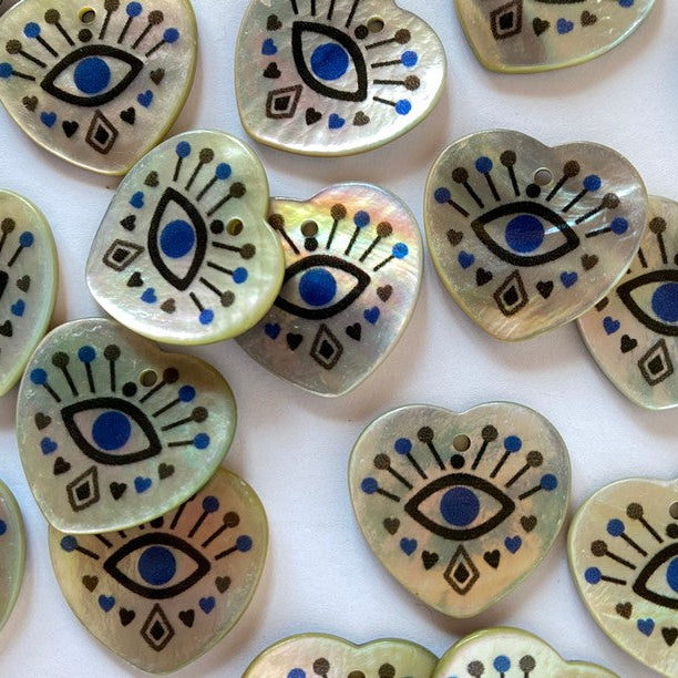 Decorative heart-shaped buttons with eye designs on a white background