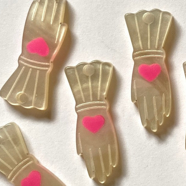 Decorative items resembling hands with pink hearts on a white background