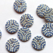 Blue buttons with white bead patterns on a white background