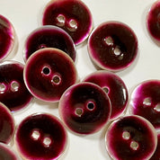 Close-up of purple buttons with a glossy finish on a white background