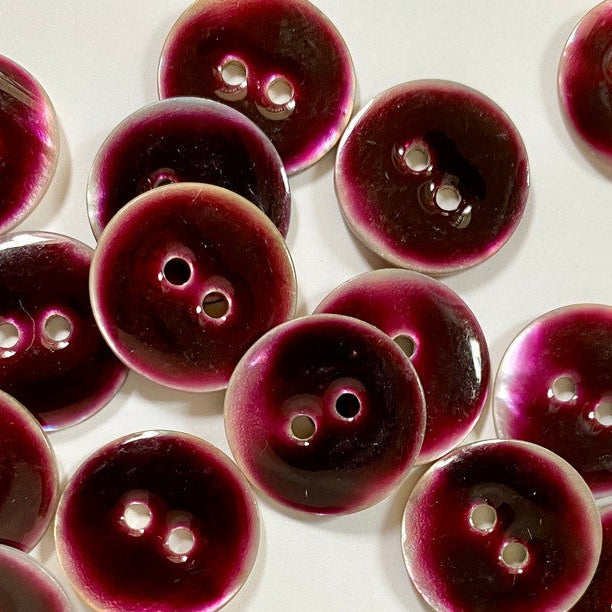 Close-up of purple buttons with a glossy finish on a white background