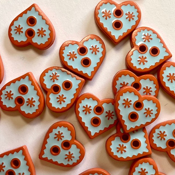 Heart-shaped buttons with decorative patterns on a light background