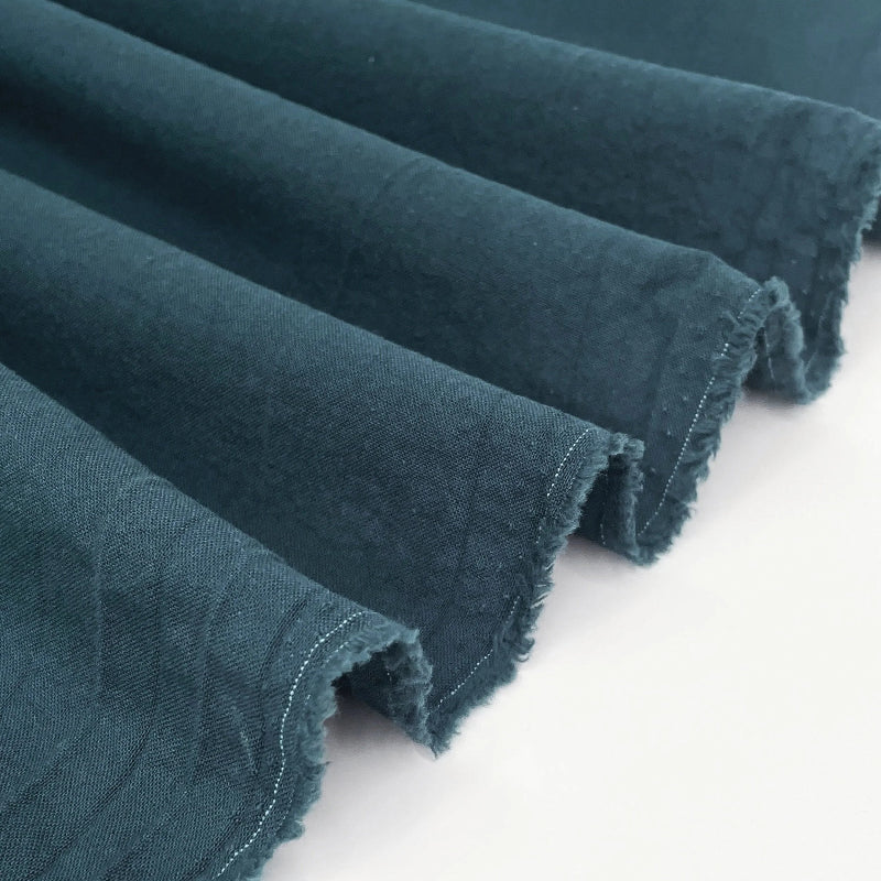 Rolls of teal fabric on a white background