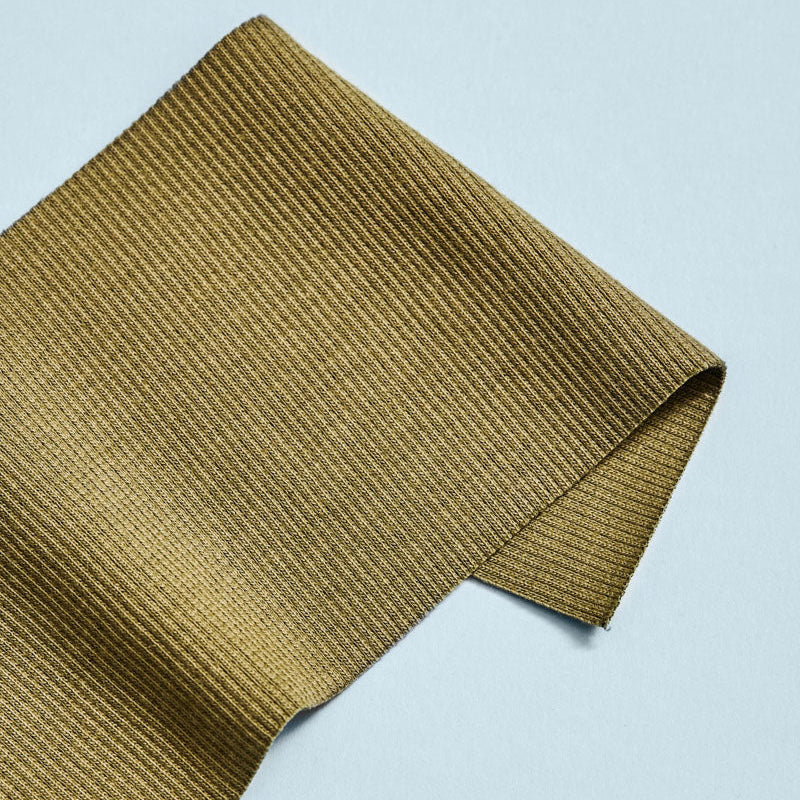Folded green fabric on a light blue background