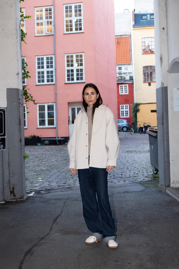 Woman standing in an urban setting with colorful buildings in the background