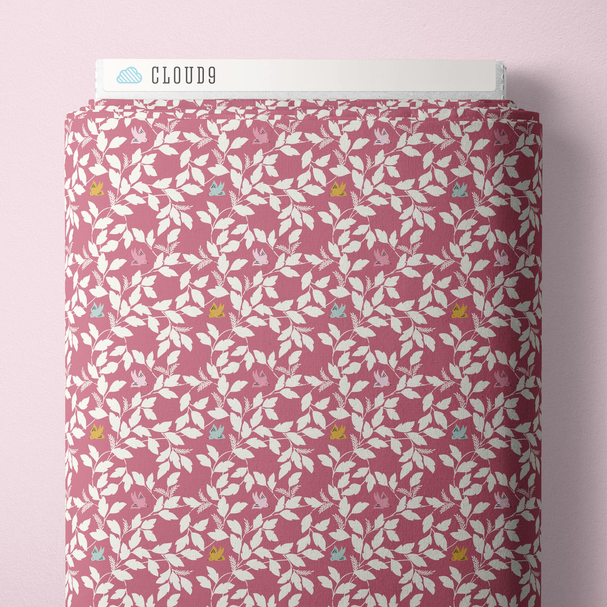 Fabric with rose colored background and white leaf print with blue, yellow, and pink birds