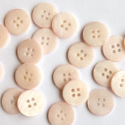 Pale pink buttons arranged on a white background