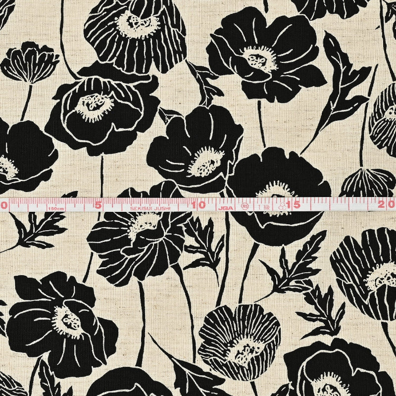 Black floral pattern on beige fabric with a ruler for scale.